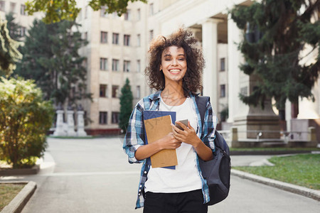 快乐微笑的非洲裔美国学生女孩在大学背景包背景图片