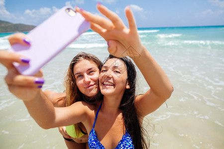 两个快乐的感女孩在海滩上背景图片