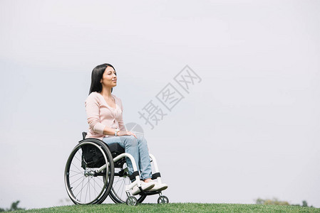 快乐的残疾妇女坐在公园轮椅上图片