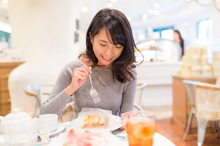 在甜点店吃蛋糕的女人图片