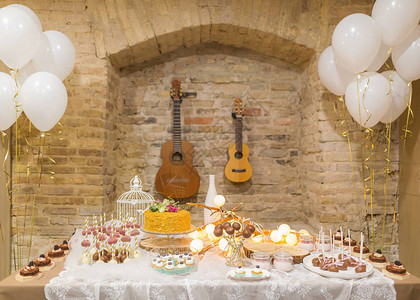 生日房间桌上有气球吉他和糖果蛋糕图片