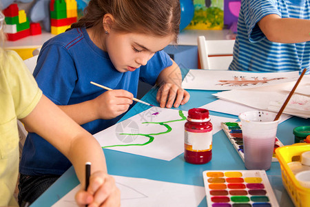 小学生在艺术学校课上画孩子在桌子上用颜料画幼儿园里的男孩和女孩绘画教育培养孩子的创造能力图片