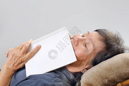 老妇人拿着书睡着了图片