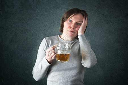一个成年女子喝啤酒的肖像悲伤的脸图片