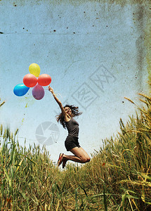 天空气球在田野里拿着彩色气球的年轻女子背景