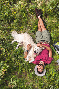 躺在绿草上的旅游和金毛猎犬的顶视图图片