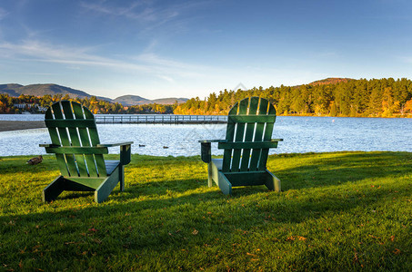 日落时在山湖岸边草坪上的一对阿迪朗达克椅子纽约州阿迪朗达克山图片