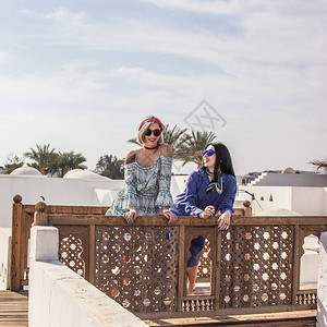 埃及度假胜地的木栏杆上倾斜着身裙子和太阳镜的图片