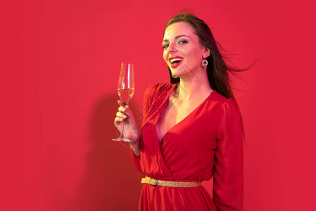 迷人的女人红色礼服喝香槟红色图片