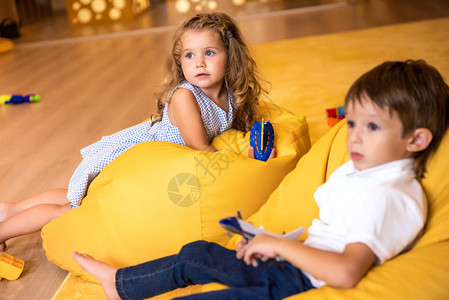 幼稚园时带着玩具的可爱孩子躺在黄图片