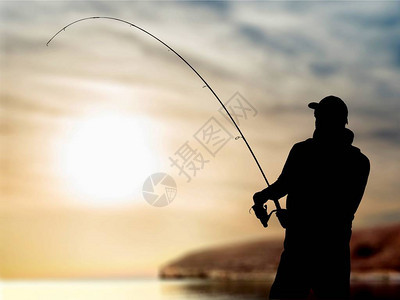 日落海岸钓鱼人的剪影图片