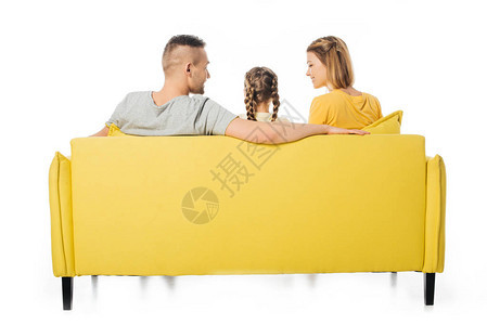 父母和女儿坐在黄色沙发上孤立在白色图片