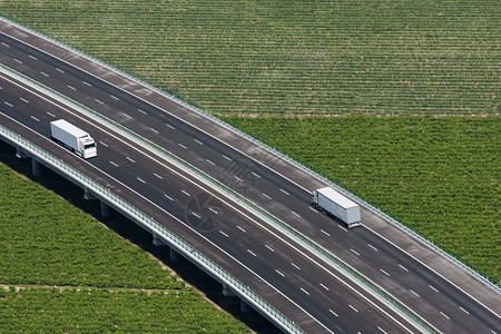 用两辆白色卡车对高速公路图片