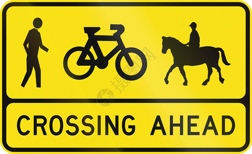 澳大利亚交通警示信号前面的行人骑自行车和排图片