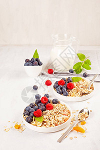 配有坚果干果和新鲜浆果的自制粮粒或食用麦芽糖健康饮食早餐图片