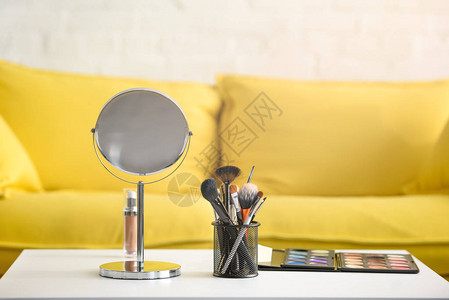 咖啡桌上黄色沙发镜子化妆刷和背景图片