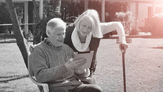 快乐的退休夫妇使用技术工具在阳光明图片