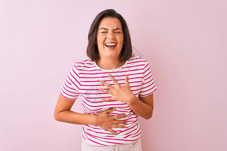 穿着条纹T恤的年轻美女站在孤立的粉红色背景上微笑图片