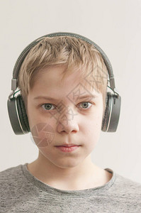 时尚的小男孩在耳机里听音乐图片