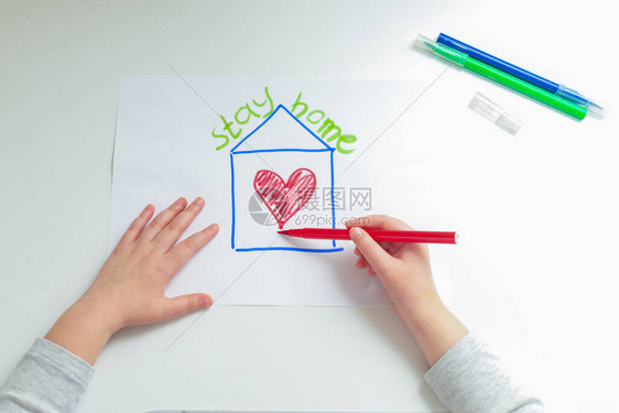 在家里的白纸上用毡尖笔在彩绘房子里画孩子的手绘心的顶部视图待图片