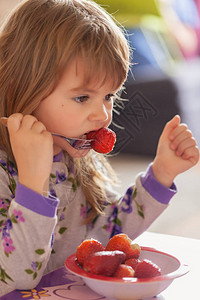 孩子在家里穿着睡衣吃早饭后吃草莓图片