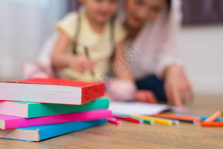 关闭有妈和孩子背景的地板上的书回到学校和教育理念儿童图片