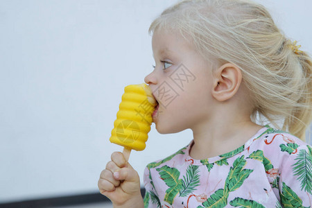 小可爱女孩吃黄色冰淇淋热切地拍了孩子的户图片