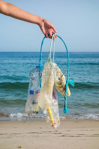 Womanhand捡垃圾和塑料清洁海滩反对气候变化和海洋污染的环保图片