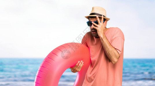 暑假戴着帽子和太阳镜的男人惊讶地用手捂着脸图片
