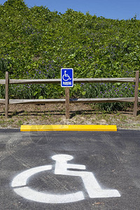 新残疾人停车位有栅栏植物和蓝天背景图片