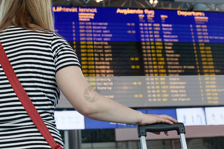 女人在机场看记分牌选择一个爱沙尼亚进图片
