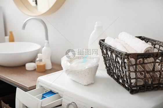 洗衣机上的洗涤剂和干净的毛巾图片