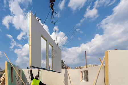 用复合sip面板建造新的现代模块化房屋蓝天背景下从事节能物业建筑开发行背景图片