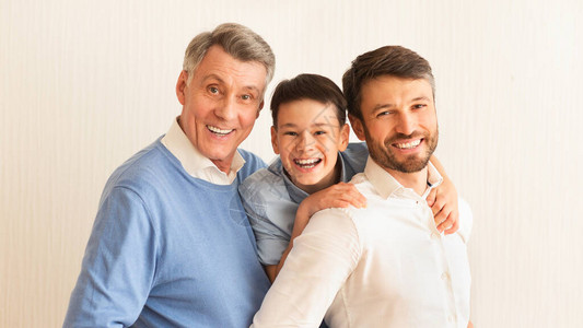 男家庭肖像与父亲和祖父微笑的男孩图片
