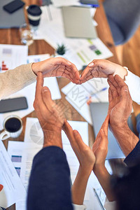 商业工人群体与手并肩站在一起在办公室打标志背景图片