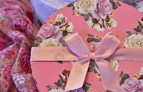 被对礼物的圆箱子捆起来的粉红丝带背景图片