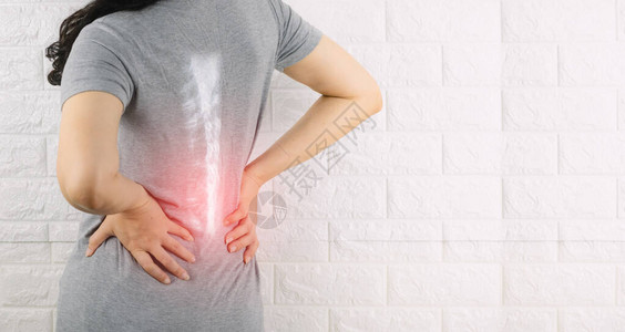 一个女人抱着腰痛脊椎骨图片