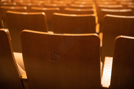 空荡的电影院里排成一排的木制观众席背景图片