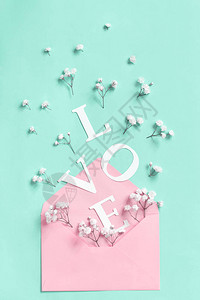 鲜花粉红信封和爱之词以浅绿色图片