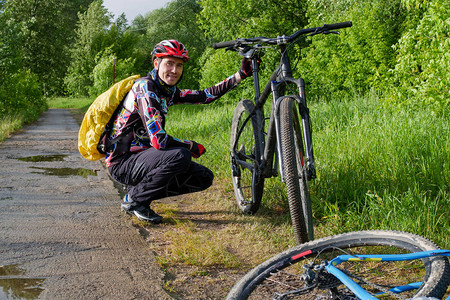 男骑自行车者白天在树林的路上骑自行车时身图片