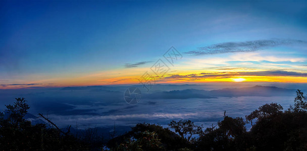 黎明时分雾云遮山的日出全景图图片