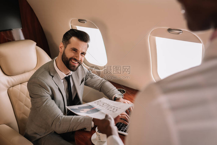 以英俊的商人为焦点看着非洲美国空姐给他报社图片