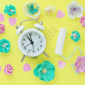 白色小闹钟棉条粉红心和彩色的人工花朵背景图片