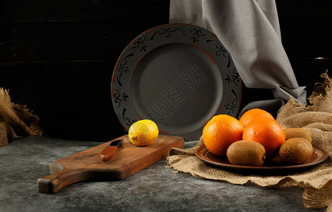 橙子柠檬和猕猴桃放在盘子里图片