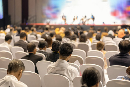 观众在会议厅或研讨会的舞台上聆听演讲者的后视图图片