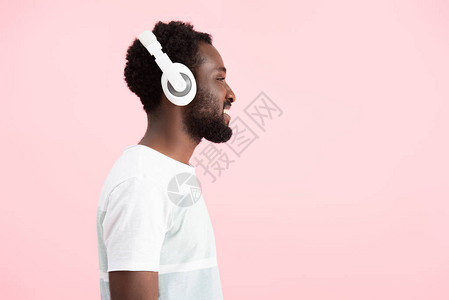 用耳机监听音乐的美国男子在粉图片