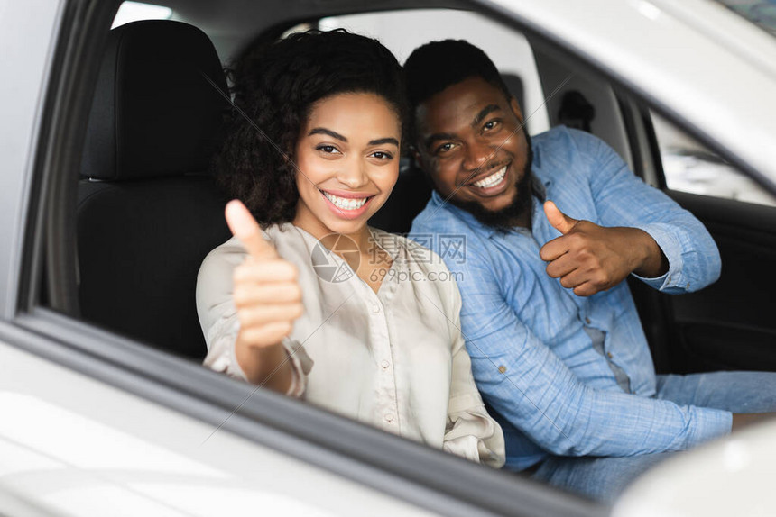 大汽车快乐的非洲夫妇在新自动购买汽车交易商店中坐着的缩略图选择图片