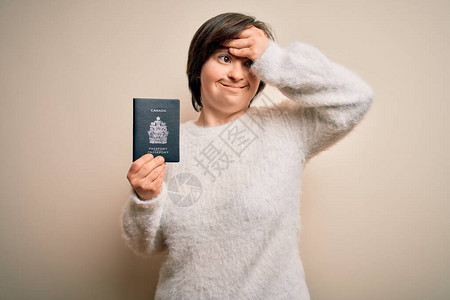 年轻的唐氏综合症旅游妇女持有加拿大护照作为旅行证件图片