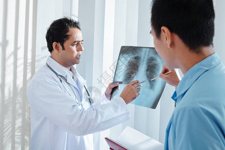 重病医生向同事展示肺部X光图片