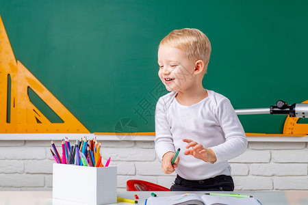 快乐可爱勤劳的孩子正坐在室内的办公桌前个别教学小学生在室图片